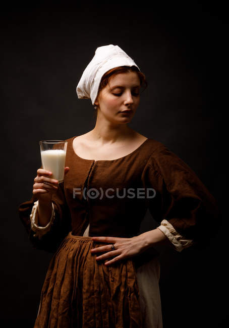 Середньовічна покоївка з молоком на чорному тлі.. — стокове фото