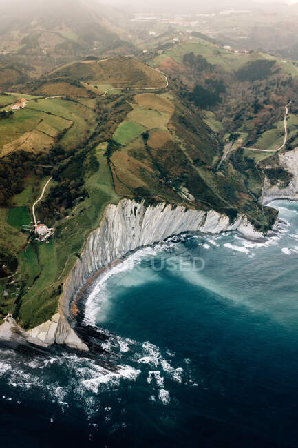 Majestic drone view of blue sea water splashing near wonderful green hills in Deva, Spain — Stock Photo