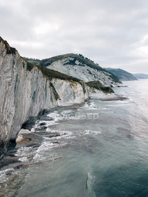 Mar acenando perto de colinas verdes — Fotografia de Stock