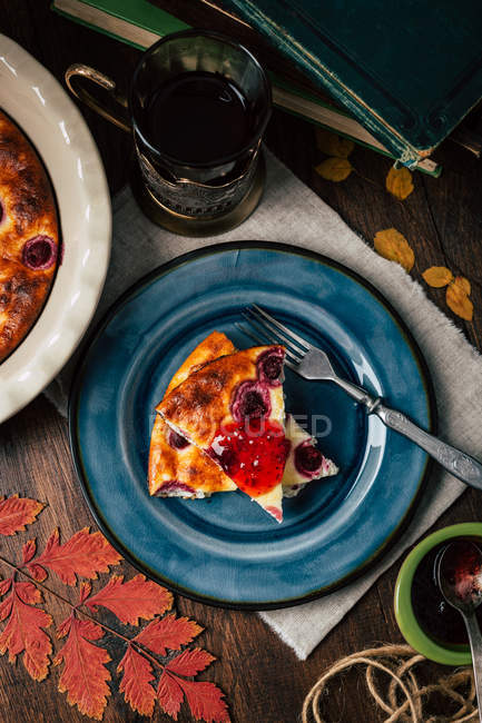Зверху керамічна тарілка з шматочками смачного пирога і чашкою гарячого чаю, розміщеного на столі . — стокове фото
