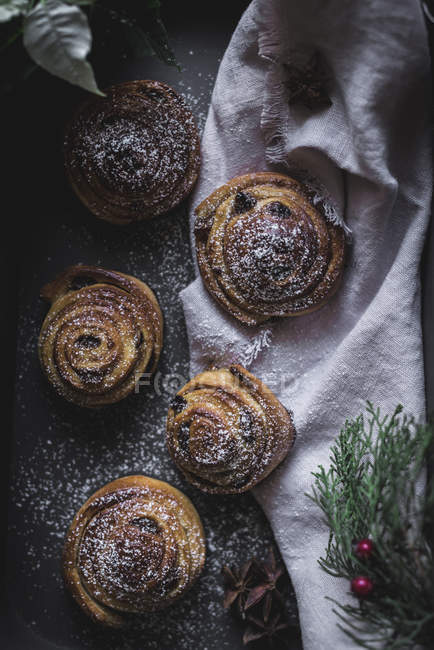 Top view of cinnamon rolls on table decorated with herbs and spices. — Stock Photo