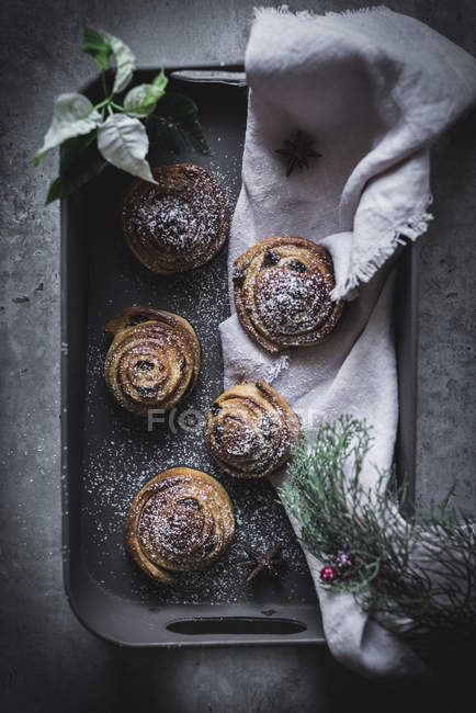 Top view of cinnamon rolls on tin decorated with herbs and spices. — Stock Photo