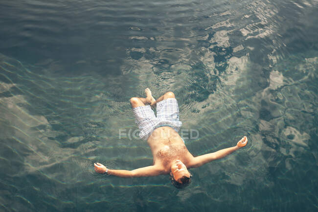 Uomo che nuota in acqua blu — Foto stock