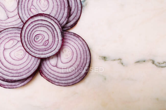 Closeup tranches d'oignon rouge frais placé sur le dessus de la table en marbre blanc — Photo de stock