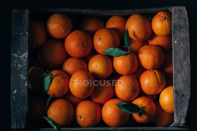 Oranges fraîches dans une vieille boîte en bois — Photo de stock