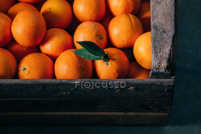 Oranges fraîches dans une vieille boîte en bois — Photo de stock