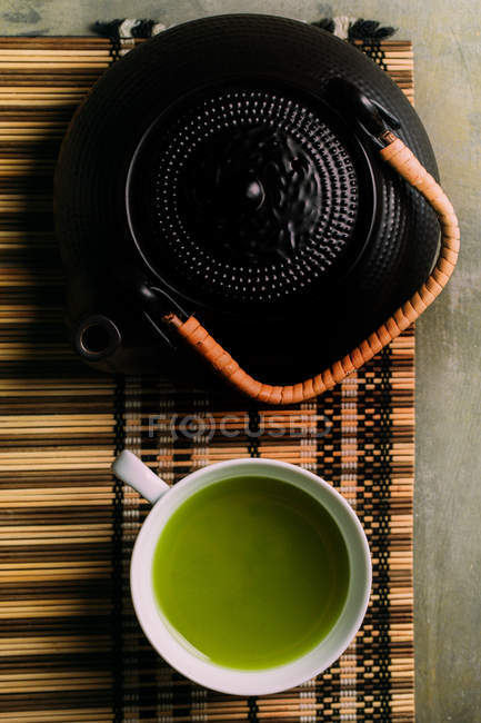 Close-up de xícara com chá matcha verde fresco, panela vintage e bambu ferramenta de preparação na mesa
. — Fotografia de Stock