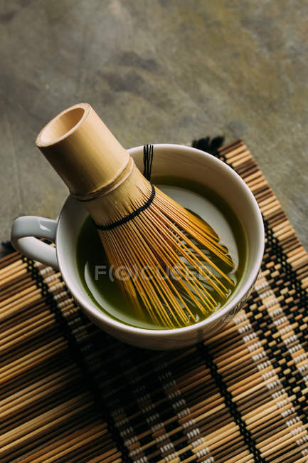 Primo piano della preparazione del tè matcha con frusta di bambù . — Foto stock