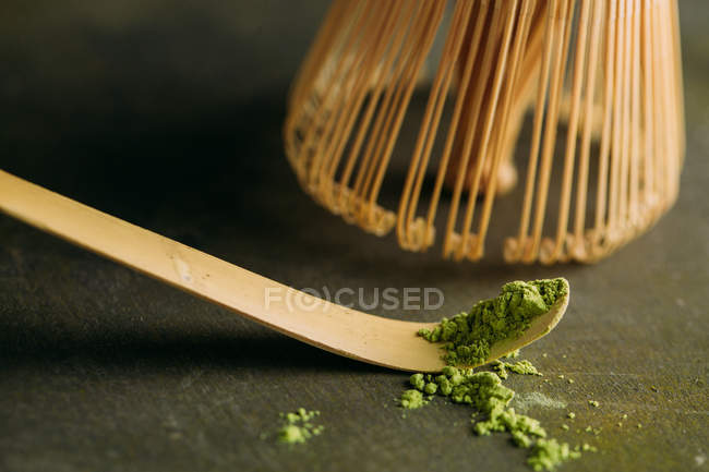 Крупним планом зелений чайний порошок мача на маленькій ложці та бамбукове вуса . — стокове фото