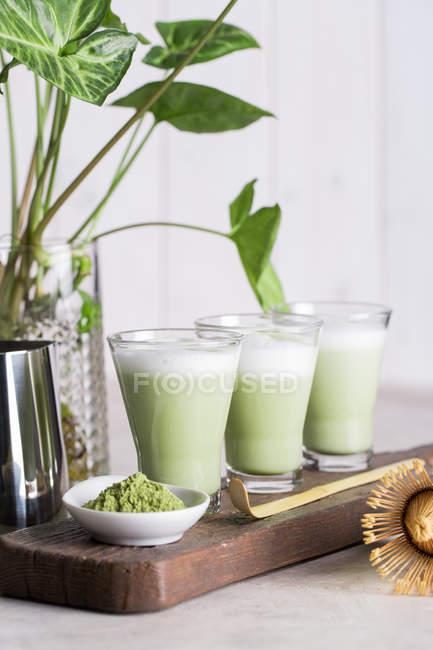 Glasses of freshly prepared matcha latte beverage on table. — Stock Photo