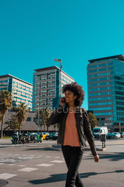 Femme aux cheveux afro marchant dans les rues d'une grande ville — Photo de stock