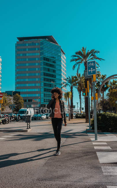 Frau mit Afro-Haaren läuft durch die Straßen einer Großstadt — Stockfoto