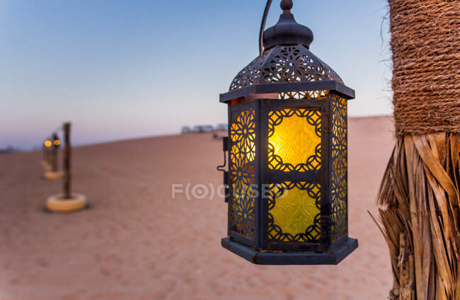 Poles with lanterns in desert — Stock Photo
