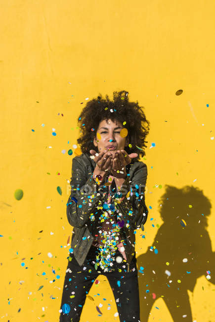 Femme noire avec des cheveux afro jetant confettis pour célébrer une journée très spéciale — Photo de stock