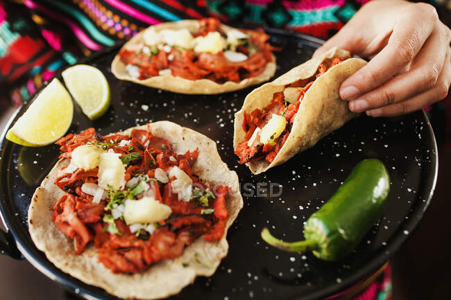 Crop hand holding taco al pastor — Stock Photo