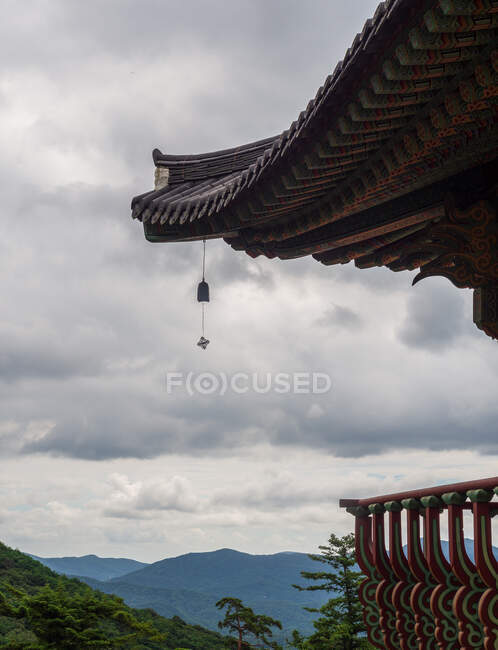 Belo telhado de pagode coreano tradicional contra o céu nublado em terreno montanhoso — Fotografia de Stock
