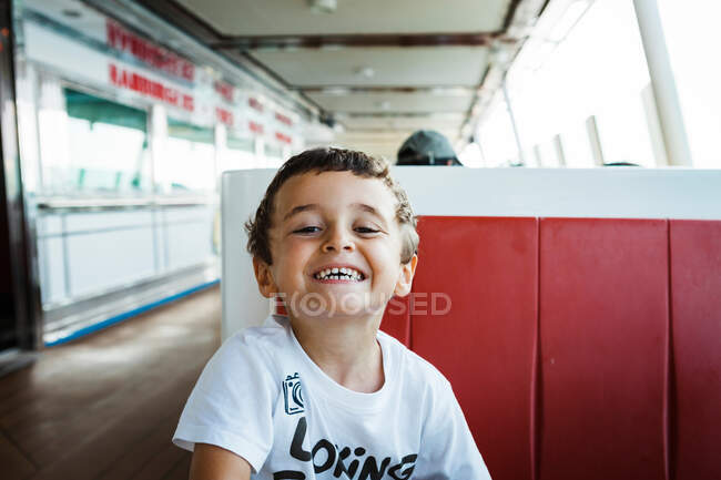 Junge lächelt auf Sitz — Stockfoto
