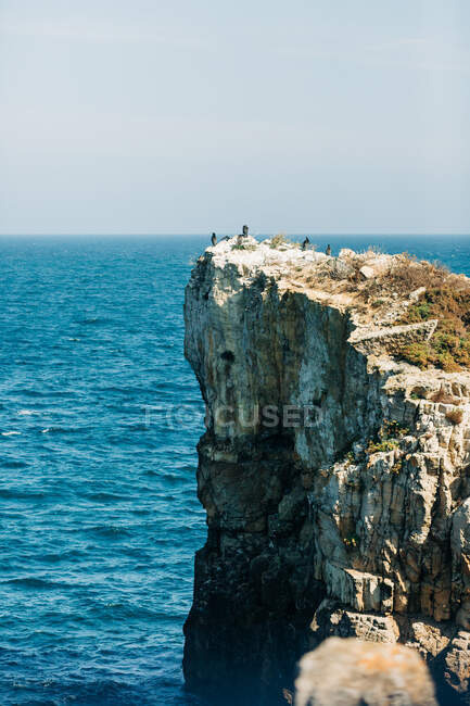 Грубая скала в синем море — стоковое фото
