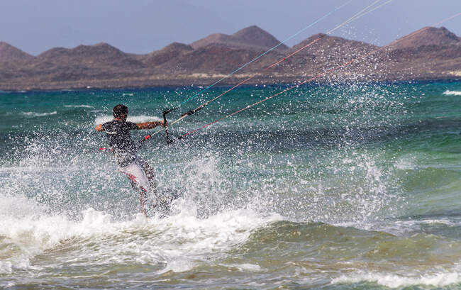 Kite boarder équitation dans éclaboussures de mer — Photo de stock