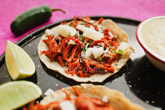 Poivre et citron vert près de tacos al pastor et sauces — Photo de stock