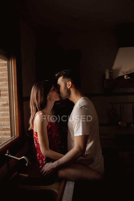 Щаслива пара цілується на кухні. — стокове фото