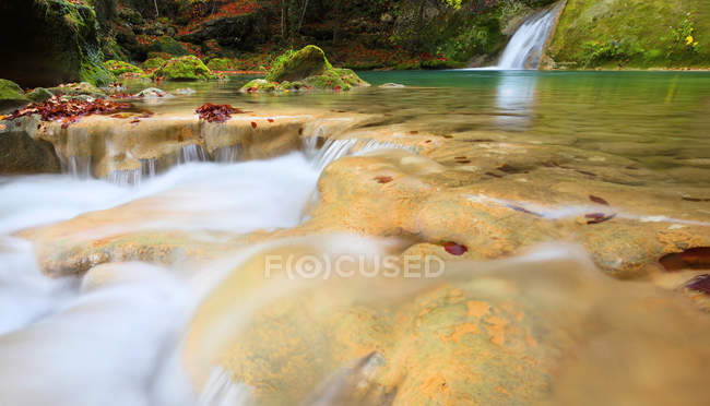 Água turquesa em reservatório com cascata e rochas verdes, Navarra — Fotografia de Stock