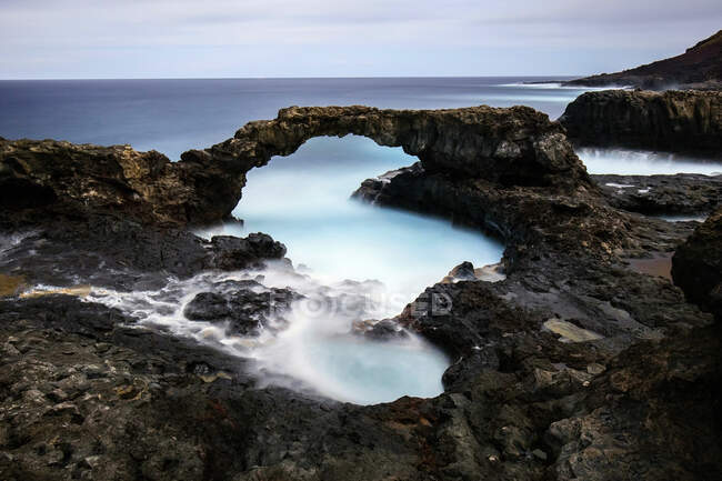 Pintoresca vista de la costa rocosa cerca de la superficie del agua y maravilloso paraíso al atardecer en la isla de Hierro, Islas Canarias, España - foto de stock