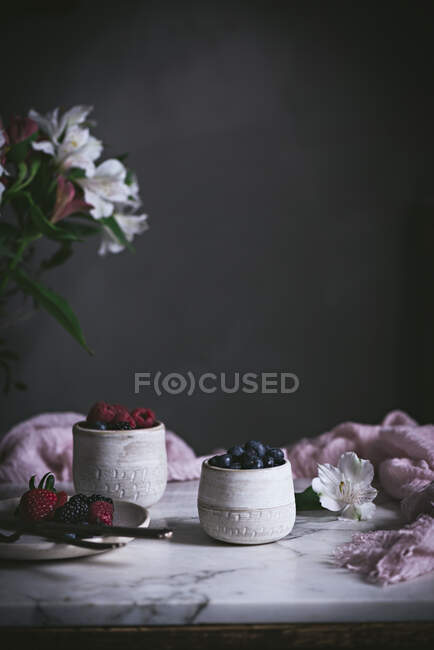 Raspberries and blueberries on glasses on table — Stock Photo