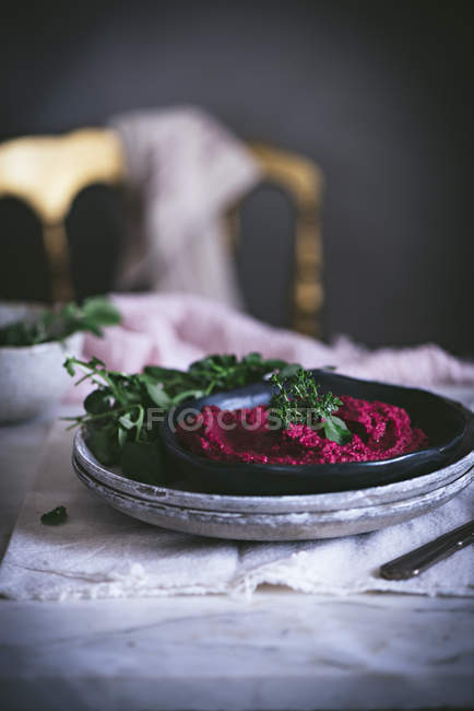 Hummus de betterave fait maison sur assiette avec des herbes — Photo de stock
