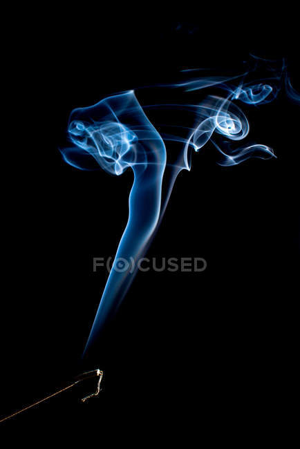 Swirls of bright blue fume on black background — Stock Photo