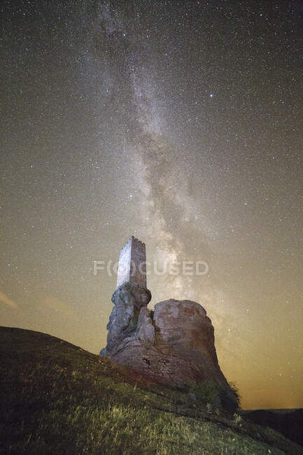 Veduta della fortezza di pietra invecchiata in cima alla scogliera rocciosa sotto il maestoso cielo stellato, Spagna — Foto stock