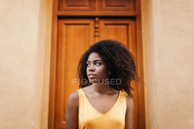 Belle femme noire regardant loin devant la porte sur la rue — Photo de stock