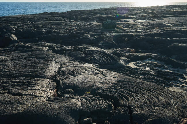 Costa áspera con rocas gruesas a orillas del mar en un día soleado - foto de stock