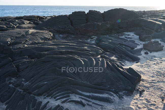 Costa acidentada com rochas grunhidas à beira-mar em dia ensolarado — Fotografia de Stock
