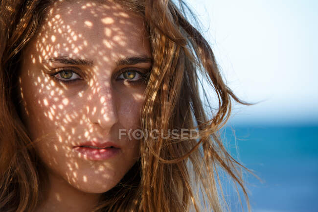 Headshot of sensual attractive woman looking at camera with passion on sunny beach — Stock Photo
