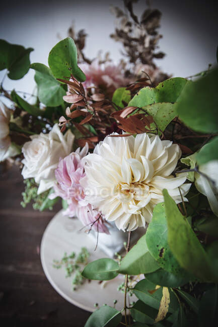 Concept de bouquet de roses sèches et fraîches, de chrysanthèmes et de brindilles de plantes en vase rétro sur planche de bois sur fond gris — Photo de stock