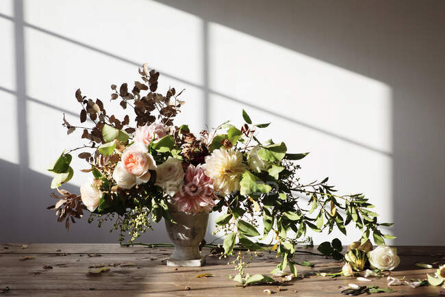 Conceito de buquê de rosas secas e frescas, crisântemos e galhos de plantas em vaso retro sobre tábua de madeira sobre fundo cinzento — Fotografia de Stock