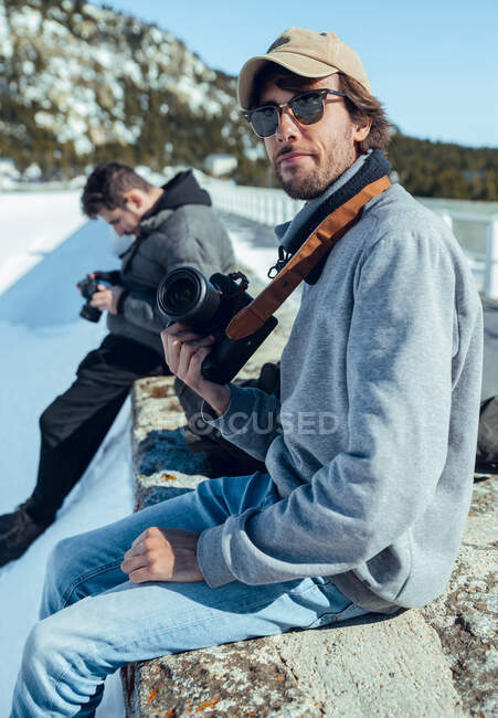 Vue latérale de jeunes photographes avec des caméras professionnelles entre les montagnes dans la neige à Cerdanya, France — Photo de stock