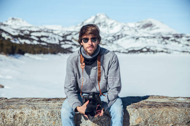 Young photographer with professional camera between mountains in snow in Cerdanya, France — Stock Photo