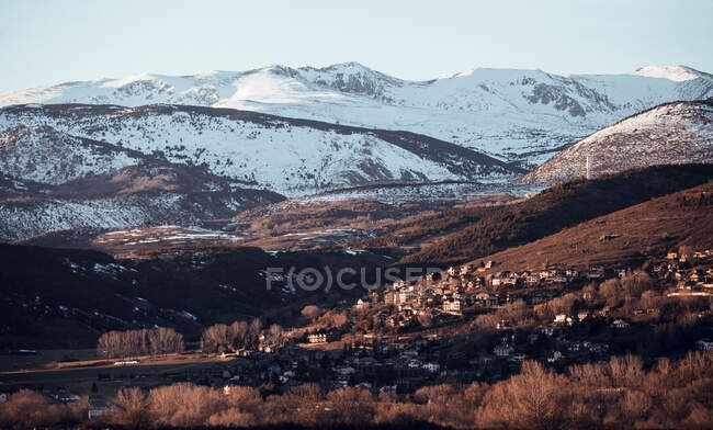 Pintoresca vista del pueblo rural entre montañas con bosque en la nieve en Cerdanya, Francia - foto de stock