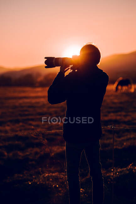 Vue de dos de mâle prenant une photo de beau paysage entre les collines par temps ensoleillé à Cerdanya, France — Photo de stock