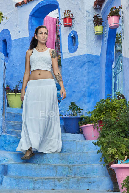 Belle femme marchant entre des maisons bleues à Marrakech — Photo de stock