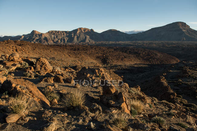 Vue pittoresque sur les terres désertiques sèches et les collines de loin par une journée sans nuages — Photo de stock