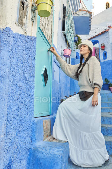 Красивая женщина, идущая между синими домами в Марракеше — стоковое фото