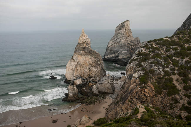 Vista para rochas costeiras e oceano ondulado em dia nublado — Fotografia de Stock