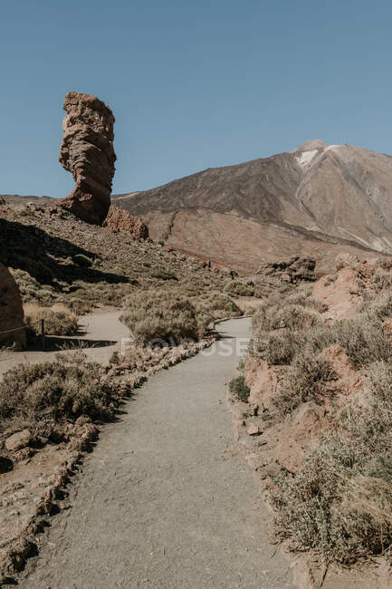 Perspectiva de la senda que conduce a la colina en la tierra seca del desierto - foto de stock