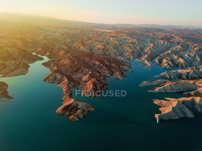 Vista aérea para a costa e pequenas colinas de areia em águas calmas à luz do sol — Fotografia de Stock