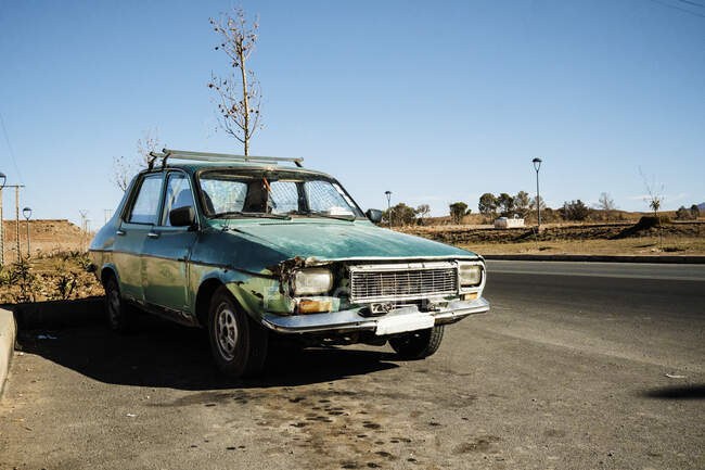 31 December 2017 - Marrakesh, Morocco: Old grungy wrecked green car parked on roadside in rural environment — Stock Photo