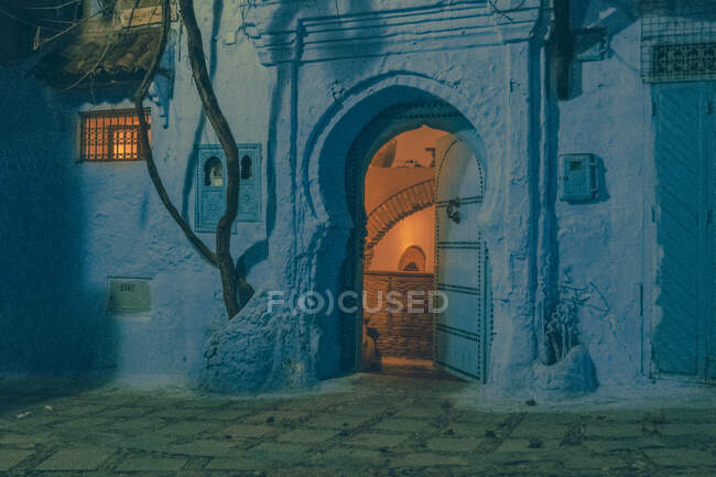 Fachada do antigo edifício de pedra com paredes brancas e portas vintage à noite em Marraquexe, Marrocos — Fotografia de Stock