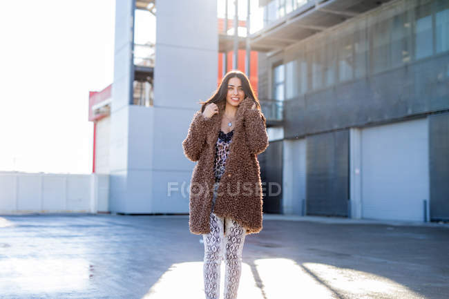 Веселая женщина, завернутая в пальто на улице — стоковое фото